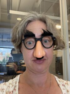 Close up of Jenny wearing a Groucho Marx nose and glasses with bushy eye brows
